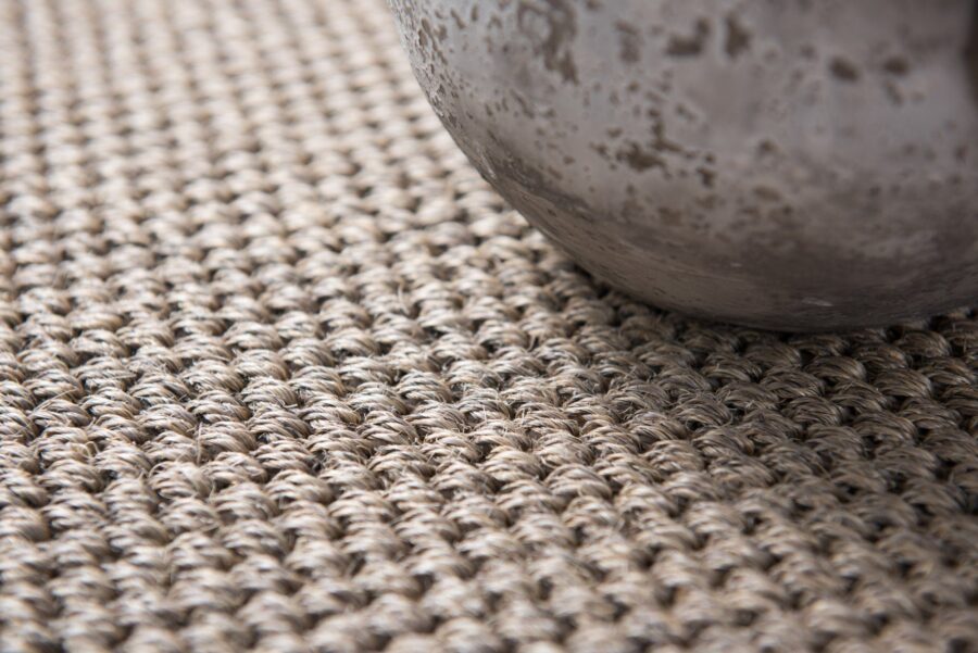 A detailed, close-up view of a high-quality Sisal Bengal Jaipur carpet featuring a tight, chunky boucle weave in natural earth tones.
