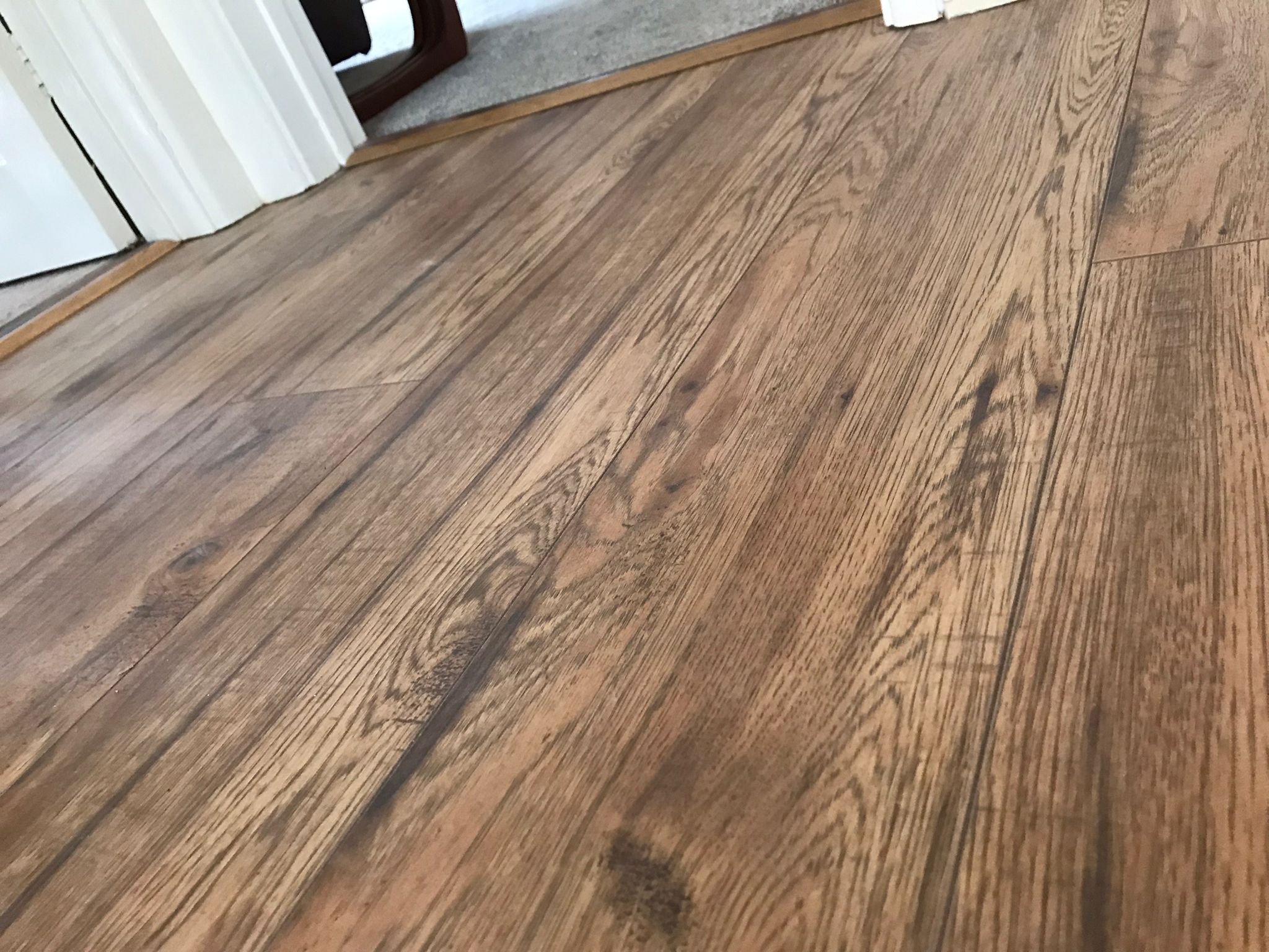 Close-up of dark oak laminate flooring fitted in a Marlborough hallway